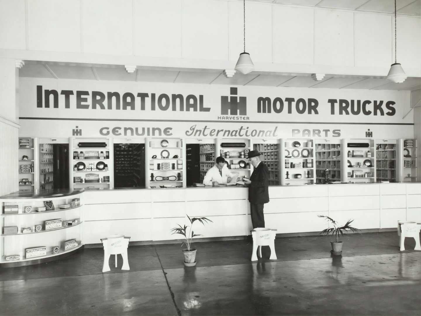 Men interacting at a vintage International Harvester parts counter.